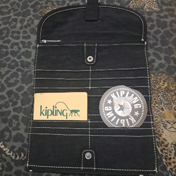 ארנק שחור של חברת Kipling מקורי עם תעודה .